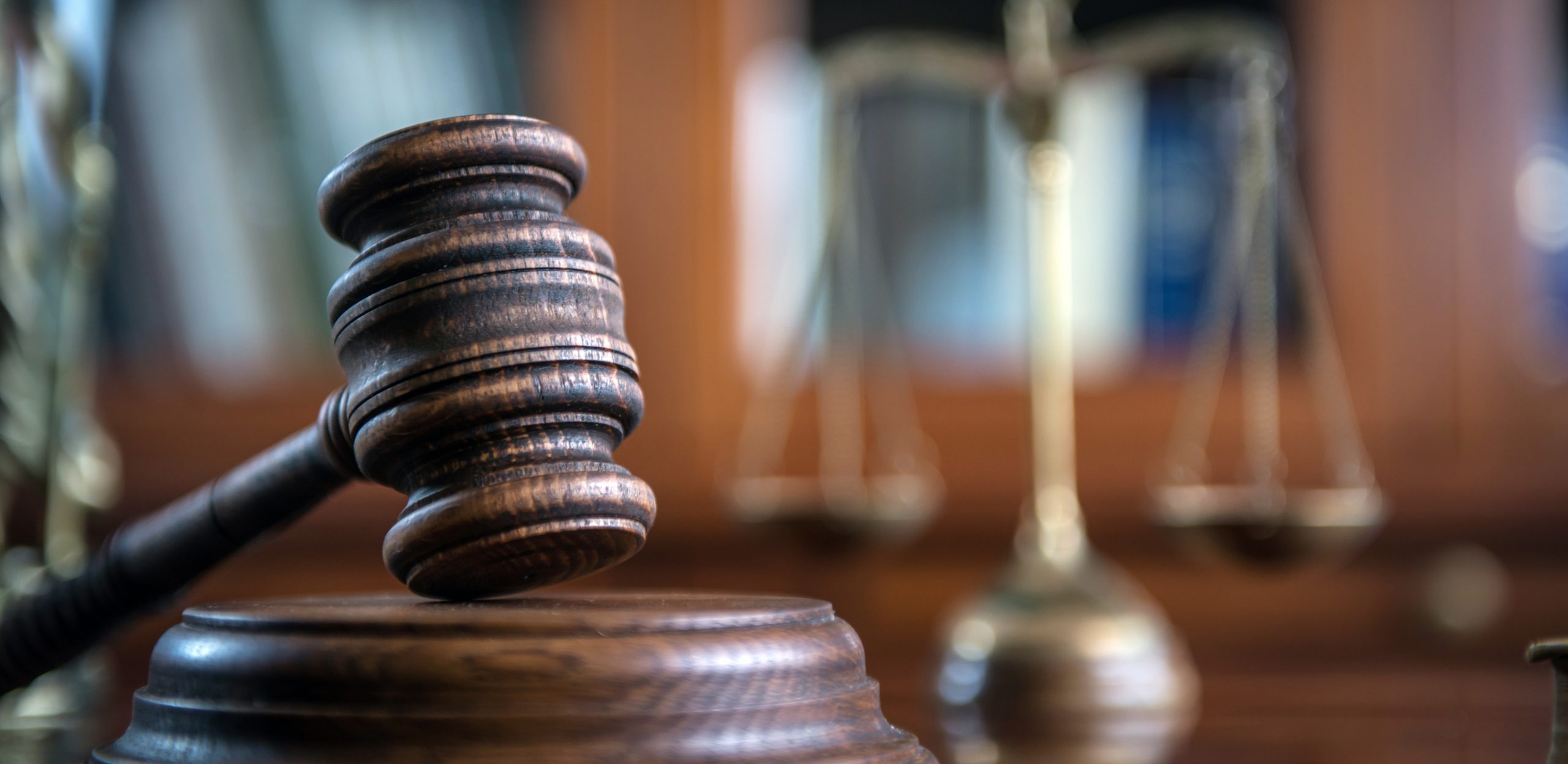 close up of judge's gavel with the scales of justice in the background