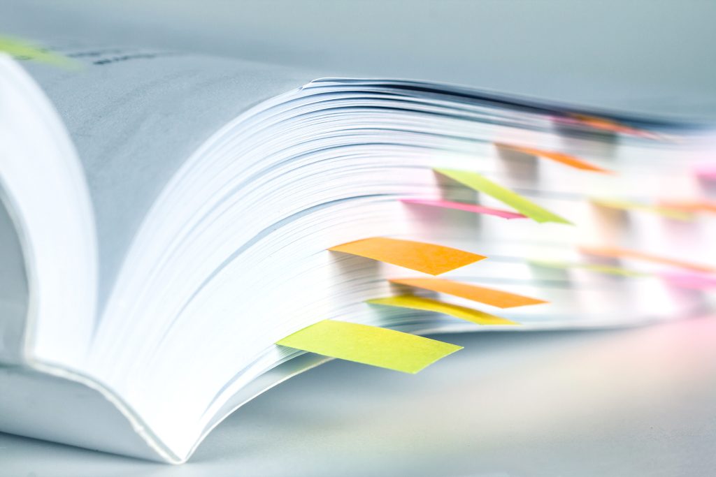 book marked by sticky notes illustrating changes Section 111 reporting on ORM