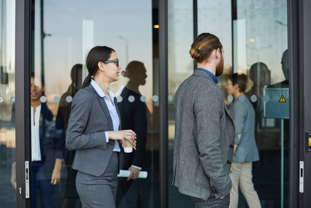 Two employees walking into office building during The great resignation